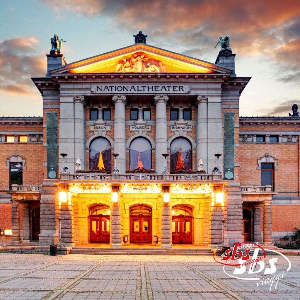 L'edificio del Teatro Nazionale di Oslo, in Norvegia, illuminato al tramonto, con tre porte di legno e colonne sotto le statue e i nomi Ibsen, Holberg e Bjornson sulla facciata, che catturano la Magia dei Fiordi.