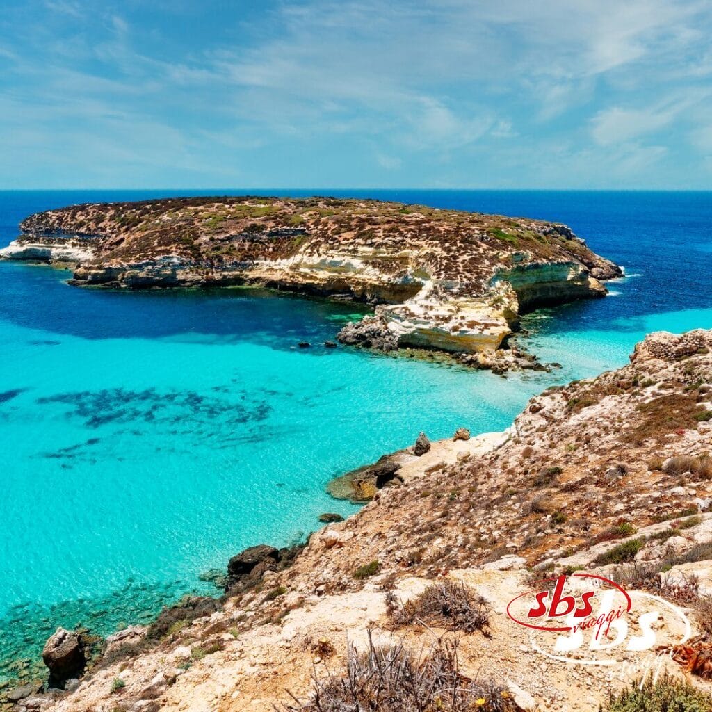 Costa rocciosa con acque turchesi e cristalline, una piccola isola e un cielo azzurro brillante: perfetta per una fuga rilassante vicino agli incantevoli villaggi o per un soggiorno tranquillo in hotel.