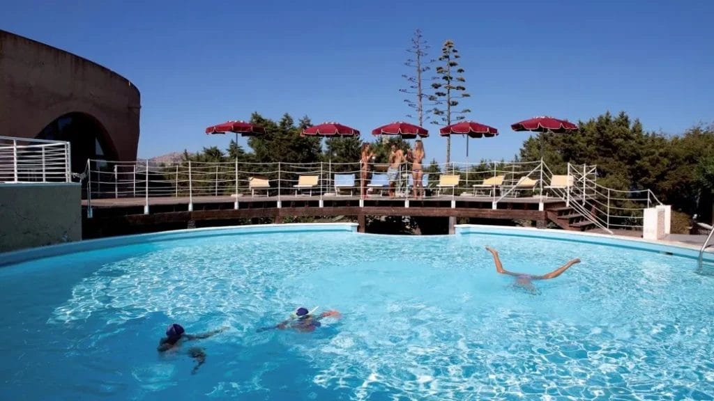 Gli ospiti possono godersi una nuotata nella piscina rotonda all'aperto del Club Esse Roccaruja, dotata di un grazioso ponte, lettini prendisole e ombrelloni rossi, il tutto sullo sfondo dello splendido scenario di Stintino.