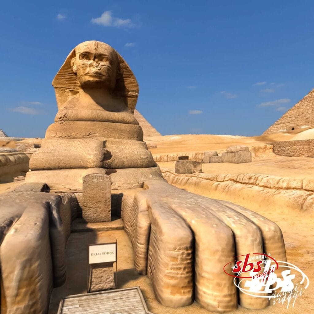 La Grande Sfinge di Giza si erge maestosa con le Piramidi sullo sfondo sotto un cielo azzurro e limpido, regalando una vista mozzafiato che rappresenta il momento clou di ogni Crociera sul Nilo o visita al Cairo.