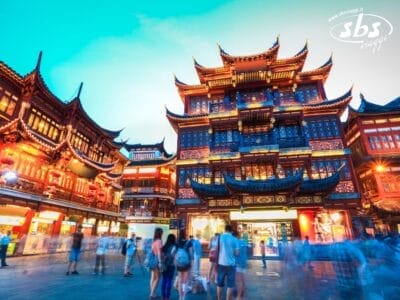 Gli edifici tradizionali cinesi con i loro tetti decorati brillano al tramonto mentre la folla passeggia, catturando lo spirito vivace di un Tour Cina Classic e l'eredità culturale del Figlio del Cielo.