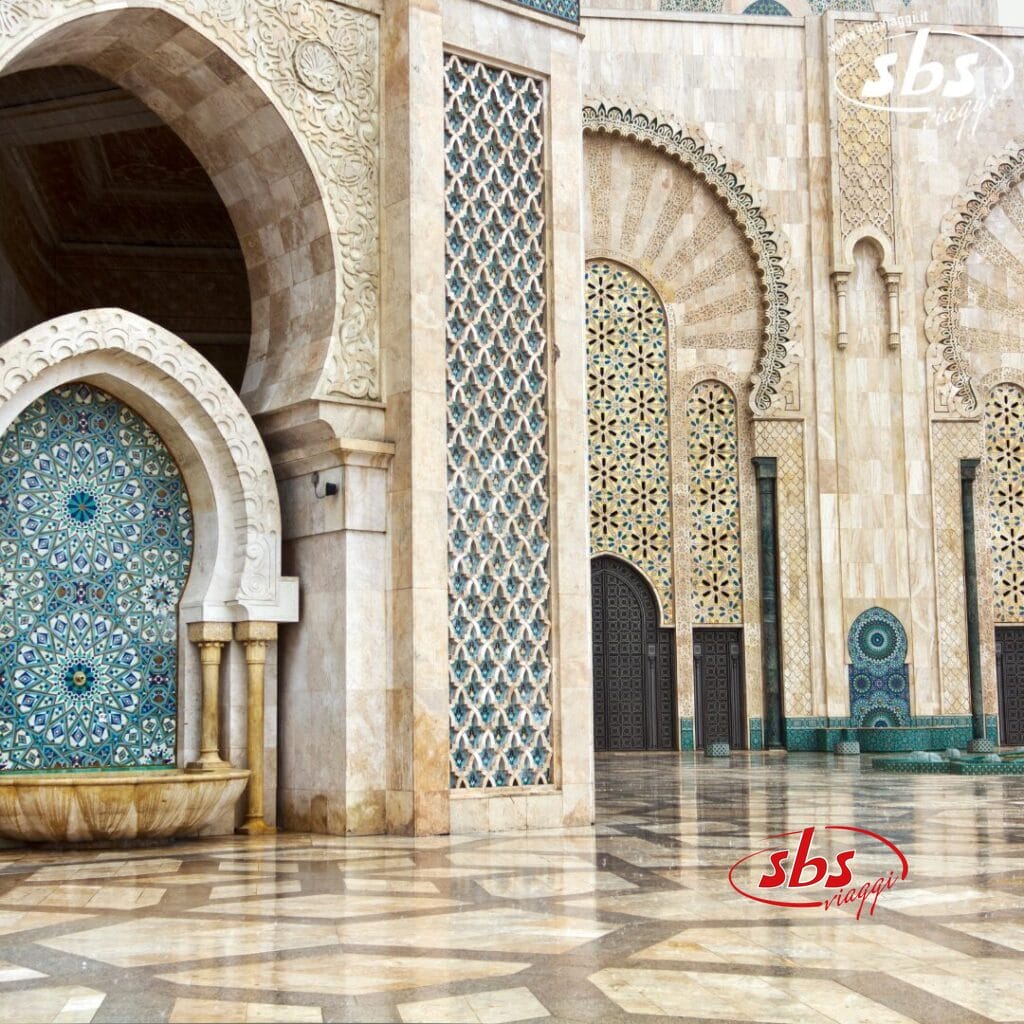 Gli archi e le colonne a mosaico della Moschea Hassan II di Casablanca, in Marocco, si riflettono magnificamente sul pavimento di marmo riflettente: una vera bozza automatica di arte architettonica.