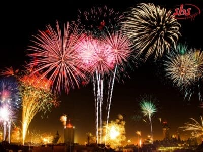 Fuochi d'artificio colorati esplodono di notte sullo skyline della città, illuminando il cielo con esplosioni vibranti per festeggiare Capodanno in grande stile.