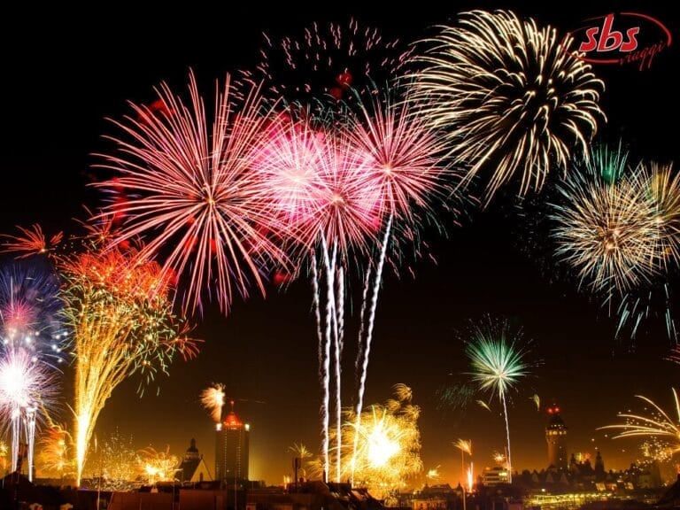 Fuochi d'artificio colorati esplodono di notte sullo skyline della città, illuminando il cielo con esplosioni vibranti per festeggiare Capodanno in grande stile.